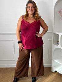 Top bordeaux à dentelle porté de face sur un pantalon large marron, montrant sa coupe fluide et sa longueur sur les hanches – Maelie | Loïcia
