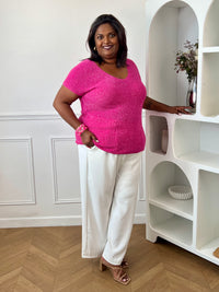 Tee-shirt fuchsia femme grande taille sans manches, doté d’un élégant col V et rehaussé de délicats fils de lurex argenté brillant. Sa coupe confortable et féminine met en valeur la silhouette tout en apportant une touche lumineuse et tendance à vos tenues du quotidien comme de soirée. Un indispensable pour allier confort, style et éclat.&nbsp;