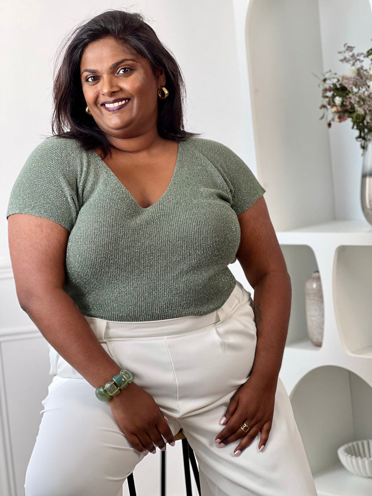 Tee-shirt kaki femme grande taille sans manches, doté d’un élégant col V et rehaussé de délicats fils de lurex argenté brillant. Sa coupe confortable et féminine met en valeur la silhouette tout en apportant une touche lumineuse et tendance à vos tenues du quotidien comme de soirée. Un indispensable pour allier confort, style et éclat.&nbsp;