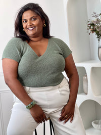 Tee-shirt kaki femme grande taille sans manches, doté d’un élégant col V et rehaussé de délicats fils de lurex argenté brillant. Sa coupe confortable et féminine met en valeur la silhouette tout en apportant une touche lumineuse et tendance à vos tenues du quotidien comme de soirée. Un indispensable pour allier confort, style et éclat.&nbsp;