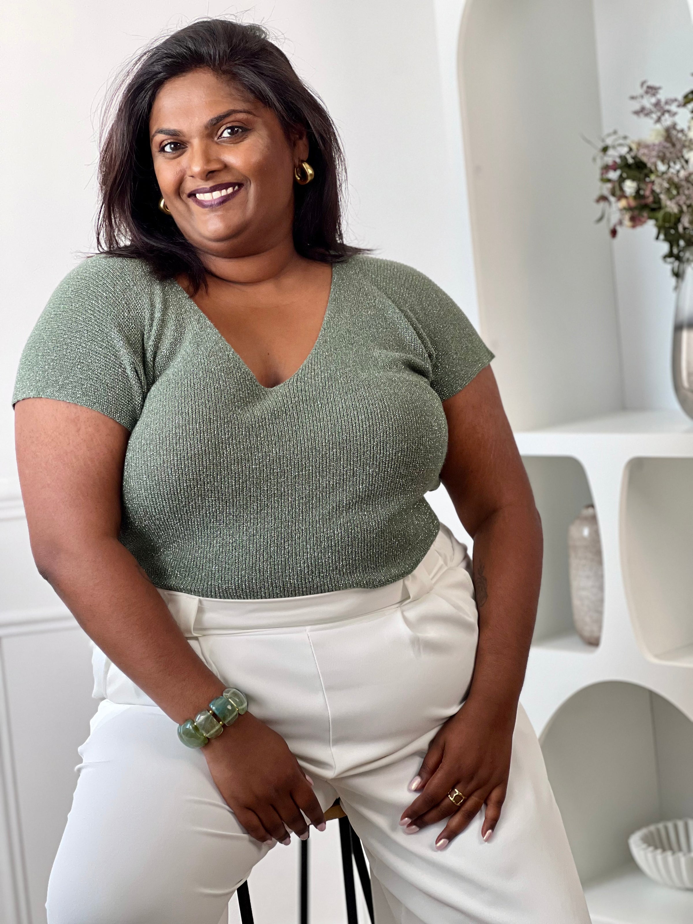 Tee-shirt kaki femme grande taille sans manches, doté d’un élégant col V et rehaussé de délicats fils de lurex argenté brillant. Sa coupe confortable et féminine met en valeur la silhouette tout en apportant une touche lumineuse et tendance à vos tenues du quotidien comme de soirée. Un indispensable pour allier confort, style et éclat.&nbsp;