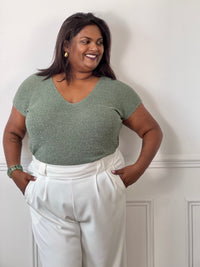 Tee-shirt kaki femme grande taille sans manches, doté d’un élégant col V et rehaussé de délicats fils de lurex argenté brillant. Sa coupe confortable et féminine met en valeur la silhouette tout en apportant une touche lumineuse et tendance à vos tenues du quotidien comme de soirée. Un indispensable pour allier confort, style et éclat.&nbsp;