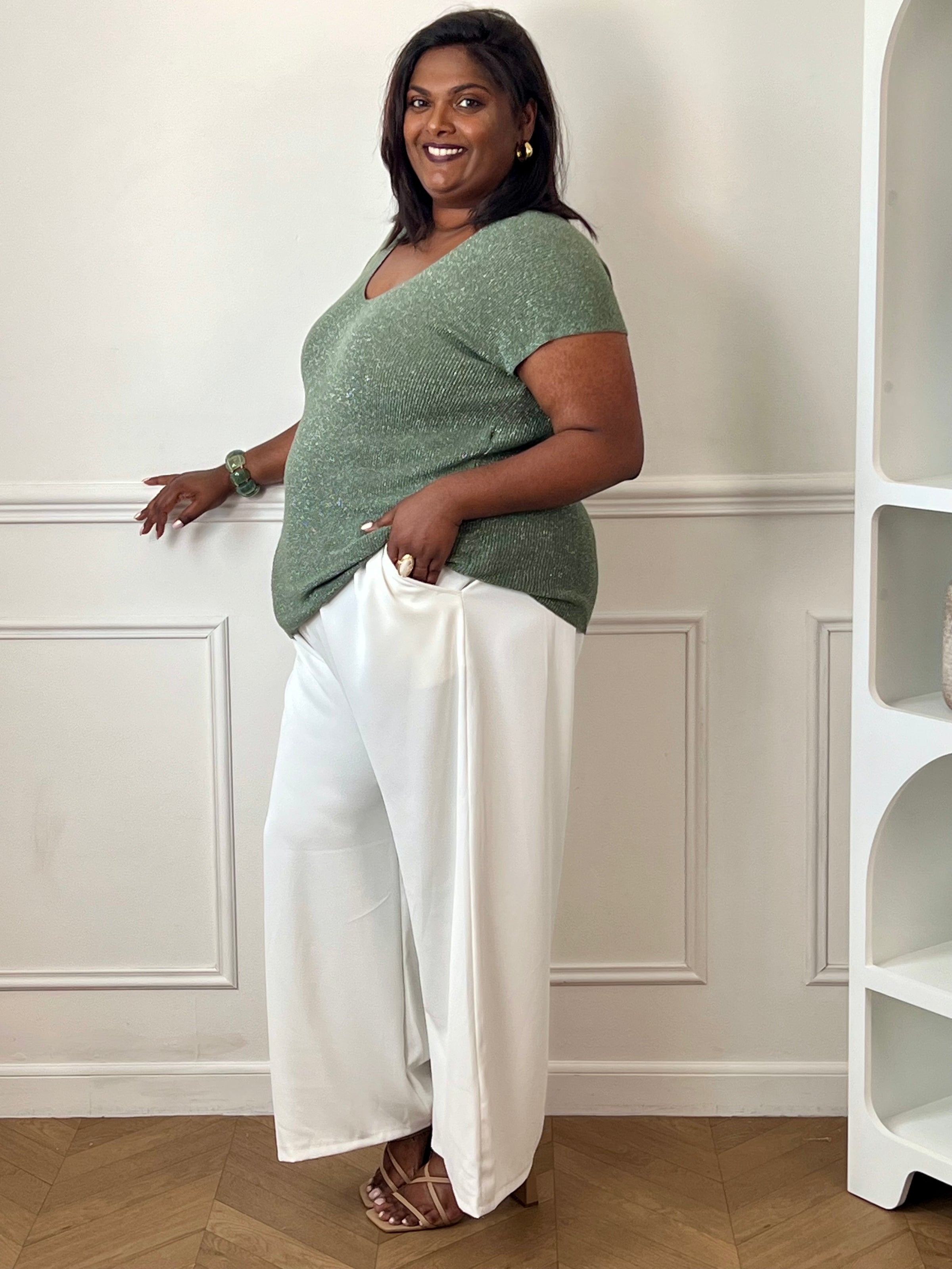 Tee-shirt kaki femme grande taille sans manches, doté d’un élégant col V et rehaussé de délicats fils de lurex argenté brillant. Sa coupe confortable et féminine met en valeur la silhouette tout en apportant une touche lumineuse et tendance à vos tenues du quotidien comme de soirée. Un indispensable pour allier confort, style et éclat.&nbsp;