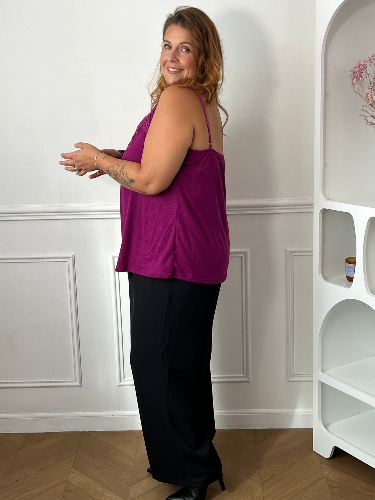 Top magenta vu de trois quarts dos, montrant ses fines bretelles et son tombé fluide sur un pantalon noir – Maelie | Loïcia