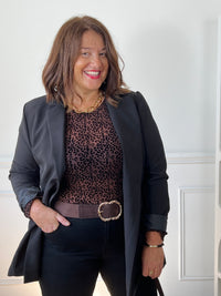 Top léopard Zeline grande taille porté sous un blazer noir, avec un pantalon noir et une ceinture marron à boucle dorée.