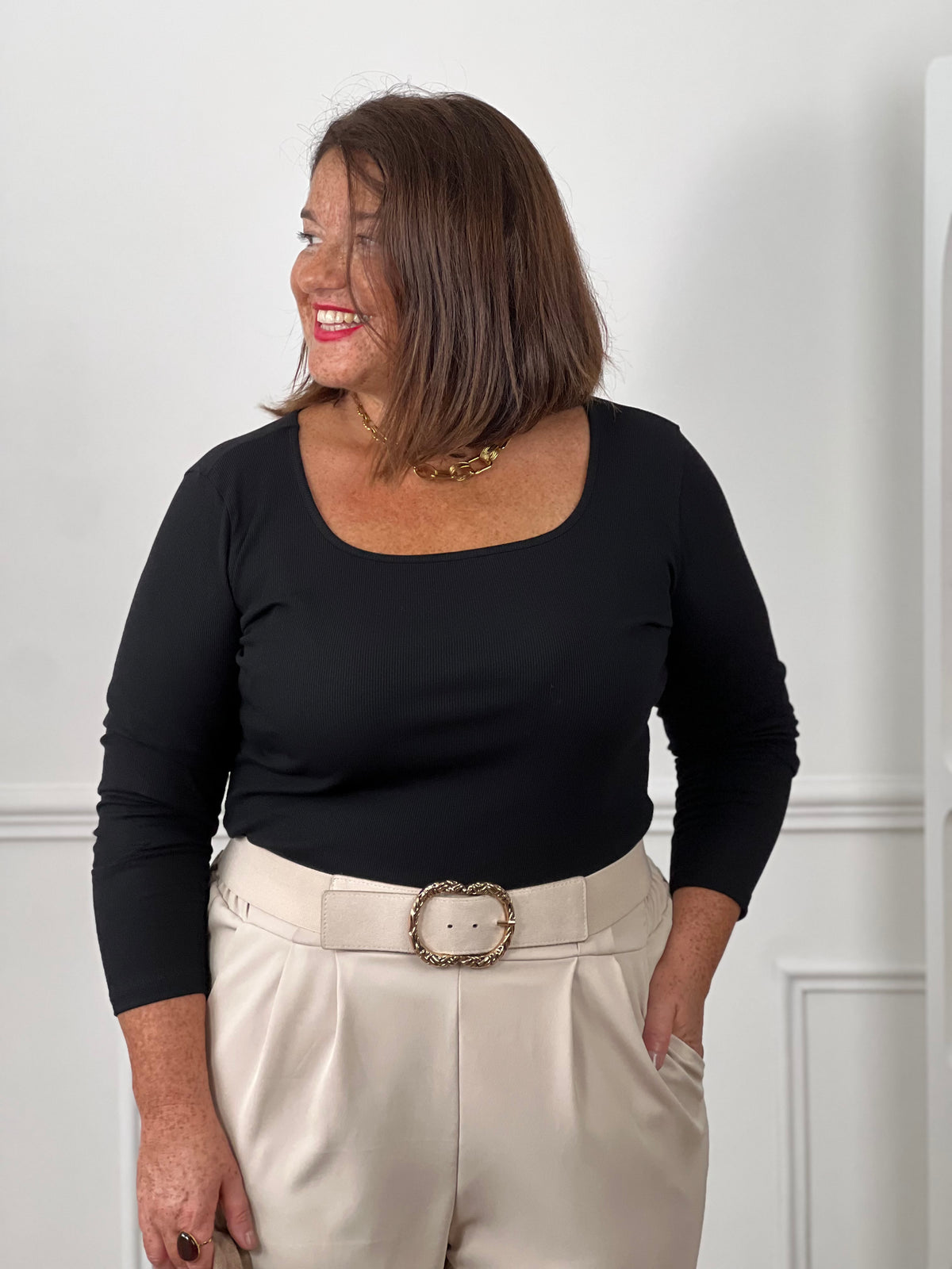 Top noir col carré manches longues côtelé grande taille - look avec pantalon large beige taille haute, ceinture beige boucle dorée et collier chaîne dorée