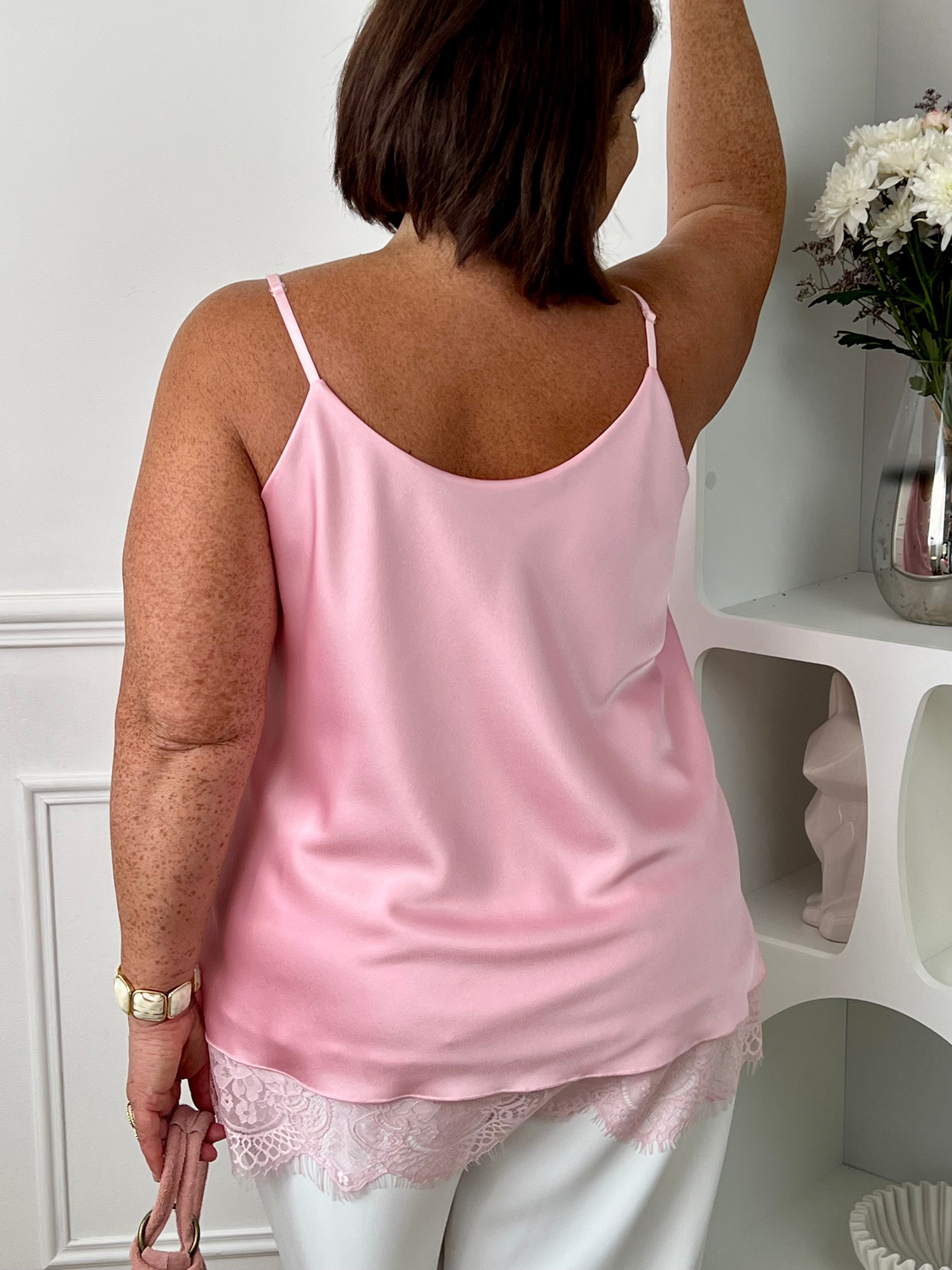 Top satiné rose clair femme grande taille, à la coupe ample et élégante. Son col rond à l'avant comme au dos offre une allure féminine, tandis que la dentelle délicate sur le bas apporte une touche raffinée. Doté de bretelles réglables, d'un effet satiné lumineux et d'une doublure confortable, ce top est idéal pour sublimer vos tenues avec élégance.