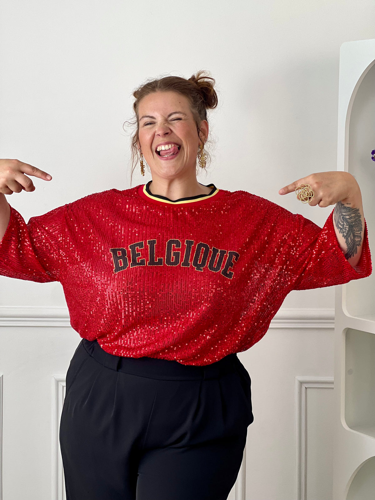 Affichez votre style avec ce top rouge à sequins grande taille femme, idéal pour apporter une touche d’éclat à vos tenues. Entièrement recouvert de sequins lumineux, il attire tous les regards tout en offrant une allure festive et tendance. Son col rond en tissu et ses manches courtes assurent un confort optimal, tandis que l’inscription « Belgique » met à l’honneur les couleurs emblématiques rouge, noir et jaune. Une pièce originale et pétillante pour un look qui ne passe pas inaperçu.