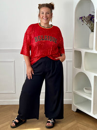 Affichez votre style avec ce top rouge à sequins grande taille femme, idéal pour apporter une touche d’éclat à vos tenues. Entièrement recouvert de sequins lumineux, il attire tous les regards tout en offrant une allure festive et tendance. Son col rond en tissu et ses manches courtes assurent un confort optimal, tandis que l’inscription « Belgique » met à l’honneur les couleurs emblématiques rouge, noir et jaune. Une pièce originale et pétillante pour un look qui ne passe pas inaperçu.