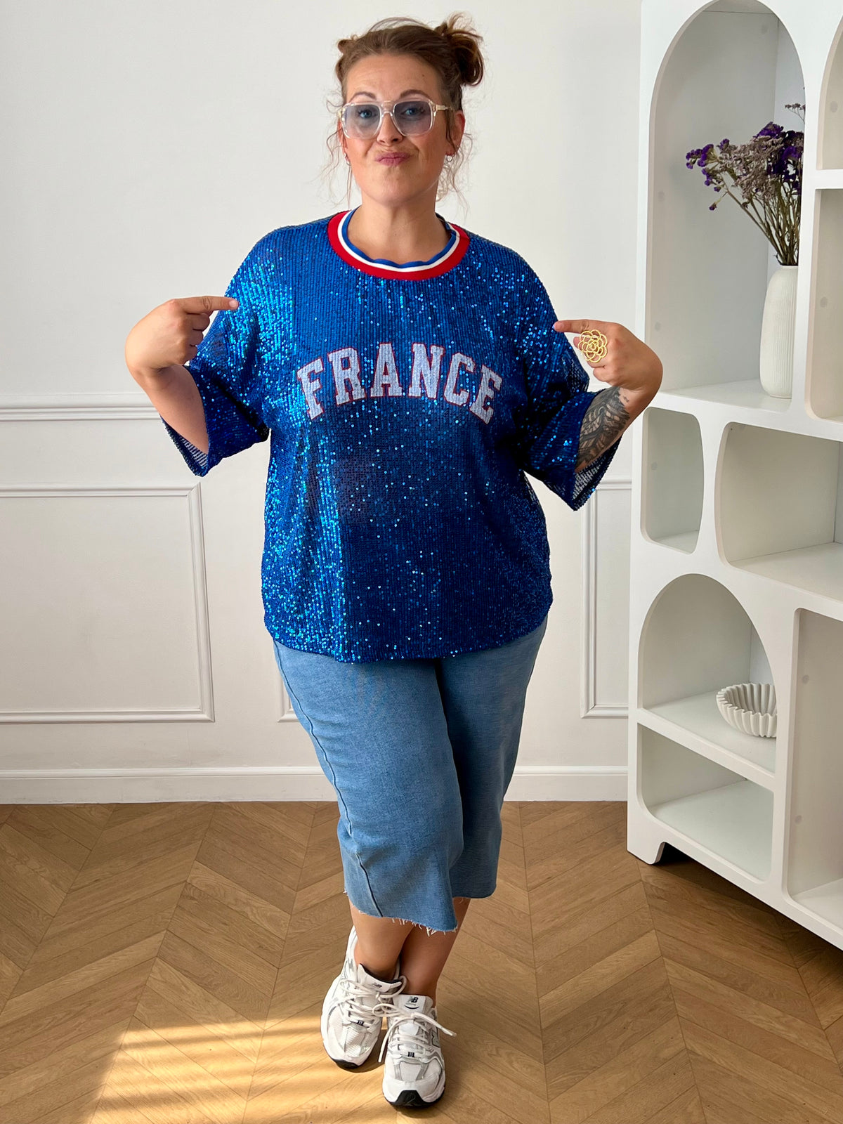 Affichez vos couleurs avec ce top bleu à sequins grande taille femme, parfait pour un look festif et original. Entièrement recouvert de sequins scintillants, il attire tous les regards tout en offrant une allure tendance. Son col rond en tissu et ses manches courtes garantissent un confort optimal, tandis que l’inscription « France » met à l’honneur les couleurs emblématiques bleu, blanc et rouge. Une pièce idéale pour soutenir votre équipe ou apporter une touche de brillance à vos tenues.