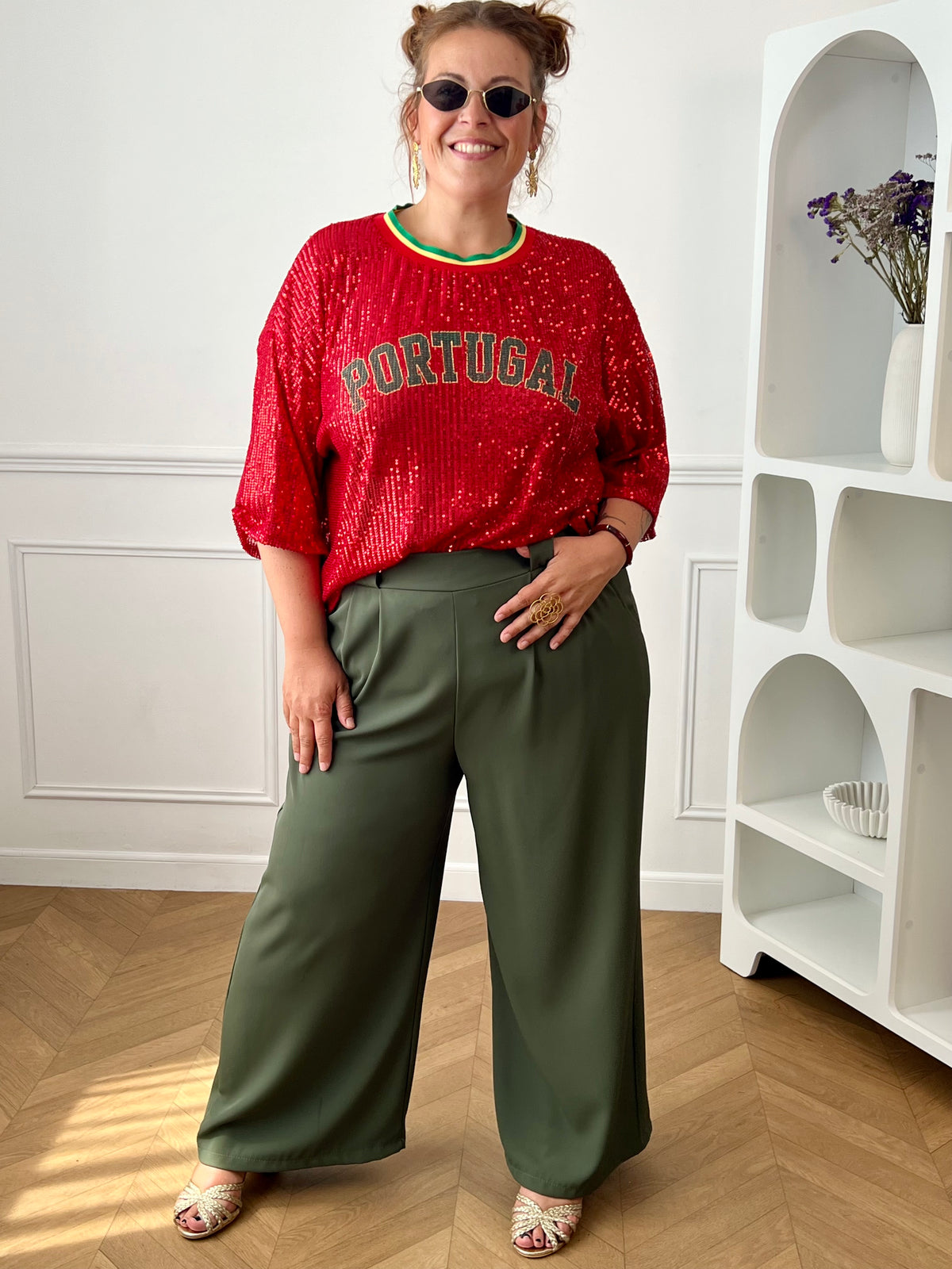 Affichez votre passion avec ce top rouge à sequins grande taille femme, parfait pour un look festif et tendance. Entièrement recouvert de sequins scintillants, il attire tous les regards tout en apportant une touche de glamour. Son col rond en tissu et ses manches courtes offrent un confort optimal, tandis que l’inscription « Portugal » met à l’honneur les couleurs emblématiques rouge, vert et jaune. Une pièce originale et lumineuse, idéale pour soutenir votre équipe ou dynamiser vos tenues.