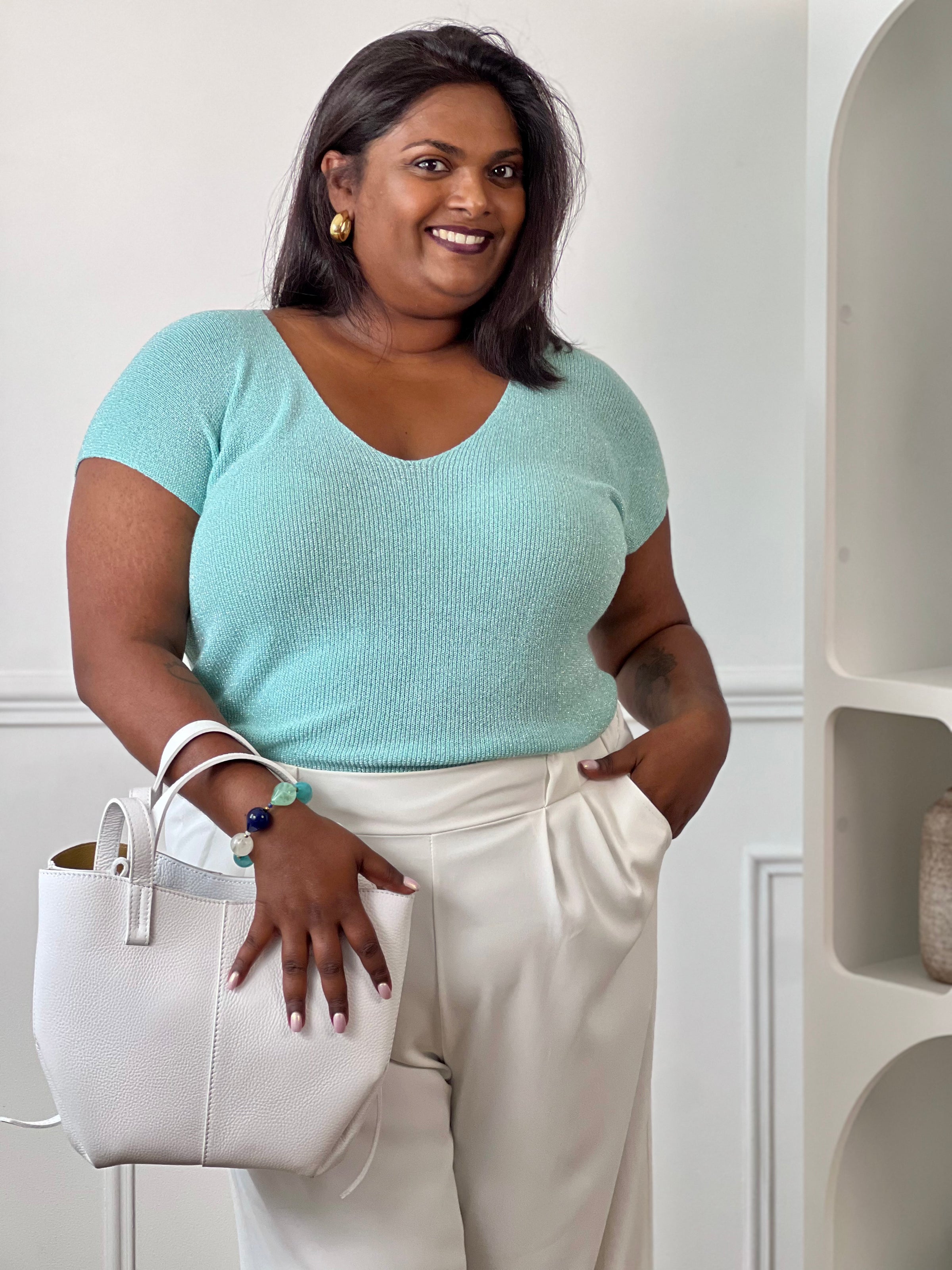 Tee-shirt turquoise femme grande taille sans manches, doté d’un élégant col V et rehaussé de délicats fils de lurex argenté brillant. Sa coupe confortable et féminine met en valeur la silhouette tout en apportant une touche lumineuse et tendance à vos tenues du quotidien comme de soirée. Un indispensable pour allier confort, style et éclat.&nbsp;