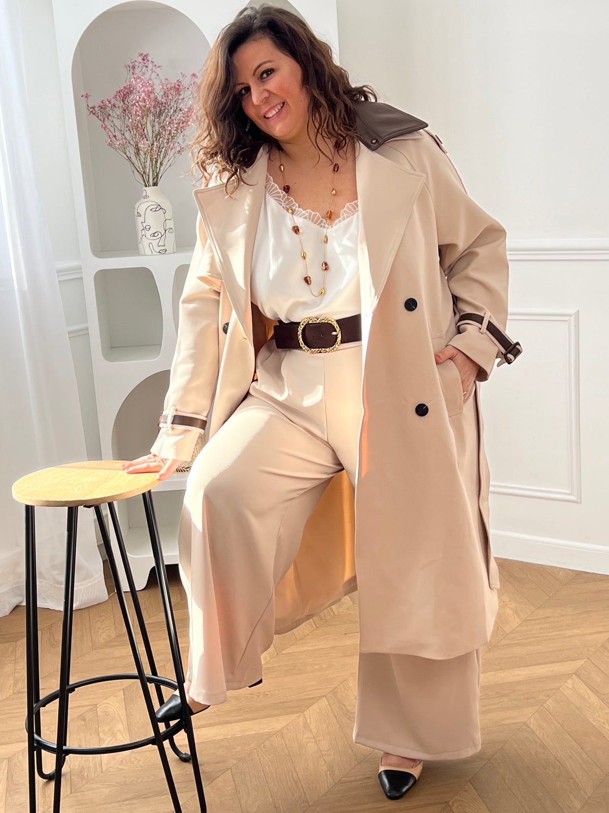 Découvrez le manteau long Elior beige et marron femme, un élégant trench intemporel. Il dispose de liens de serrage aux poignets, de passants avec ceinture amovible pour marquer la taille et de deux poches latérales pratiques. Son double col à revers est rehaussé de détails en simili cuir marron amovibles au col et aux poignets. Une pièce chic et raffinée pour la mi-saison.