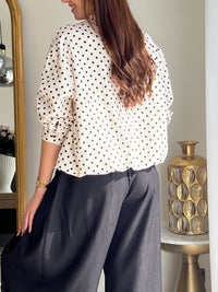 Veste femme écrue à pois noirs, légère et tendance, parfaite pour compléter un look chic et décontracté. Dotée de manches longues, d’une fermeture éclair et de poches latérales pratiques, elle allie style et fonctionnalité. Les boutons aux manches et l’élastique sur le bas apportent une finition moderne et confortable. Un indispensable facile à porter en toute saison.
