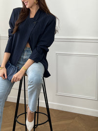 Optez pour cette veste bleu marine à rayures au style moderne et structuré. Sa coupe asymétrique croisée sur le devant lui apporte une allure élégante et originale. Dotée de manches longues, d’un col montant et d’un bouton sur le haut, elle est doublée pour plus de confort. Une veste noire chic, idéale pour compléter vos tenues.