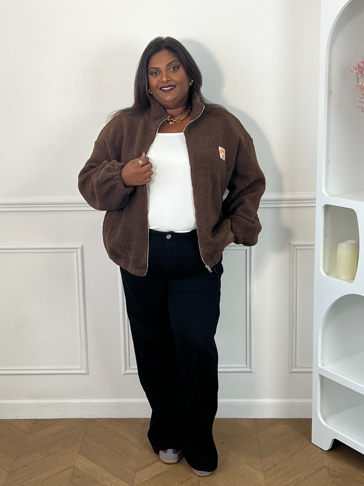Veste marron zippée portée ouverte sur un top blanc avec un pantalon large noir – Bess | Loïcia