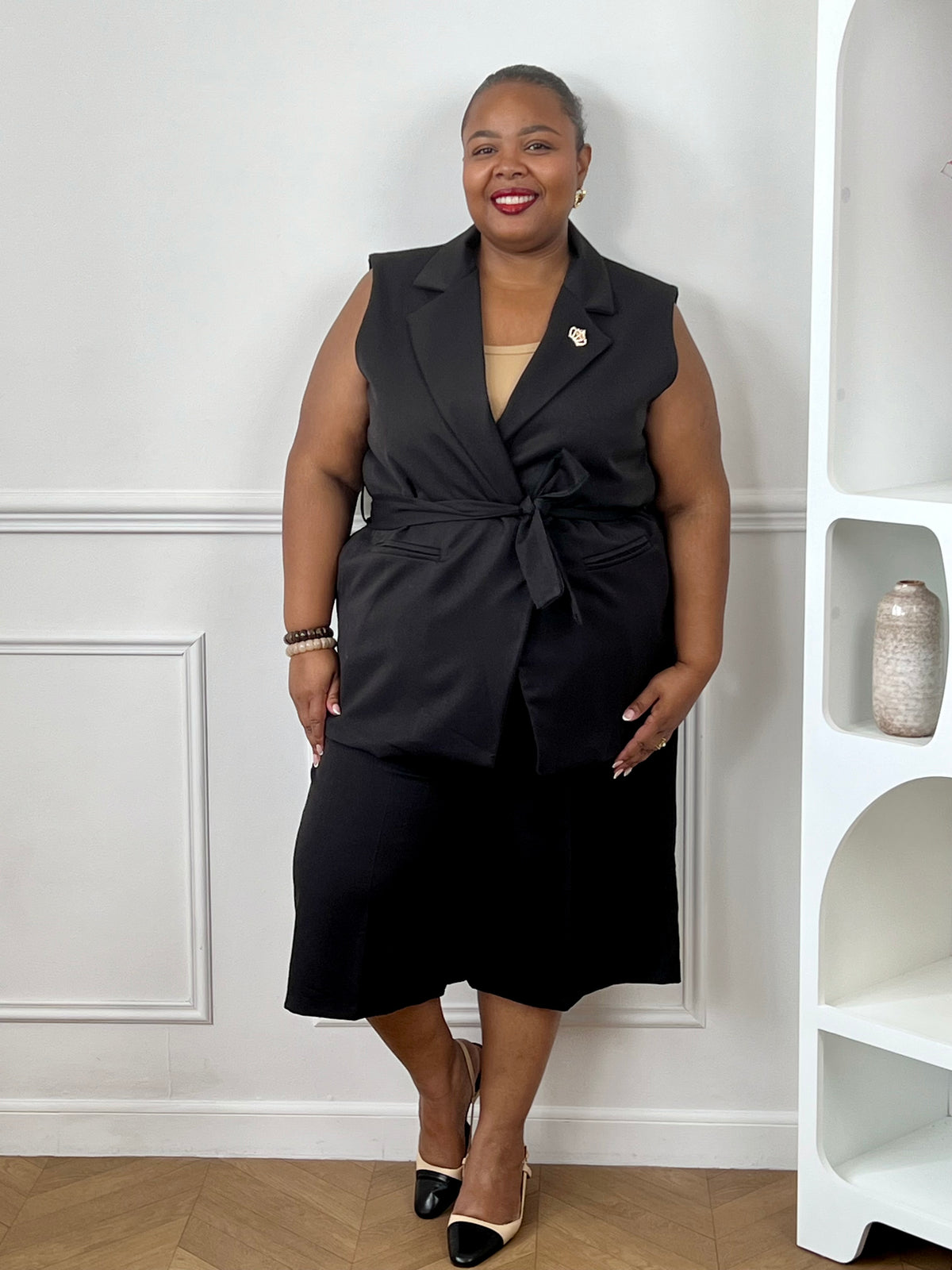 Veste noire longue grande taille avec col à revers et ceinture amovible pour un look chic.