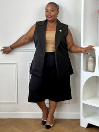 Veste noire sans manches associée à un bermuda assorti pour une tenue élégante et moderne.