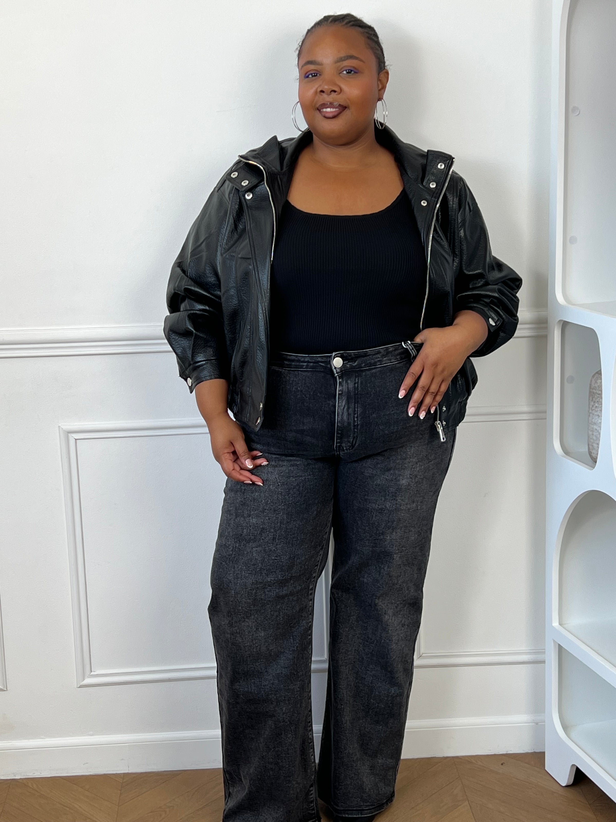Blouson noir doublé à manches longues et taille élastiquée.