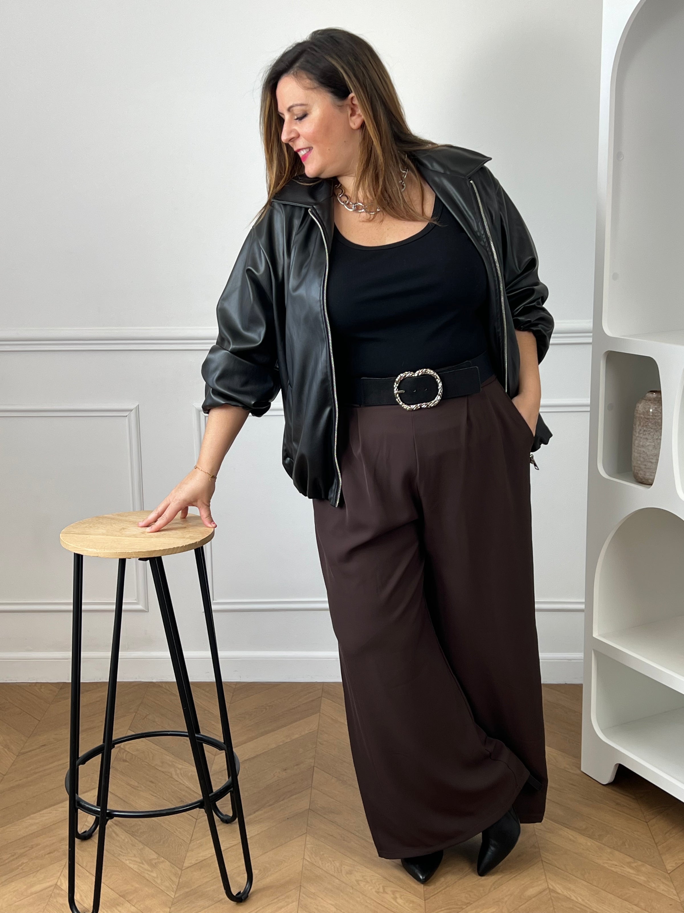 Blouson bomber noir avec fermeture éclair argentée sur le devant.