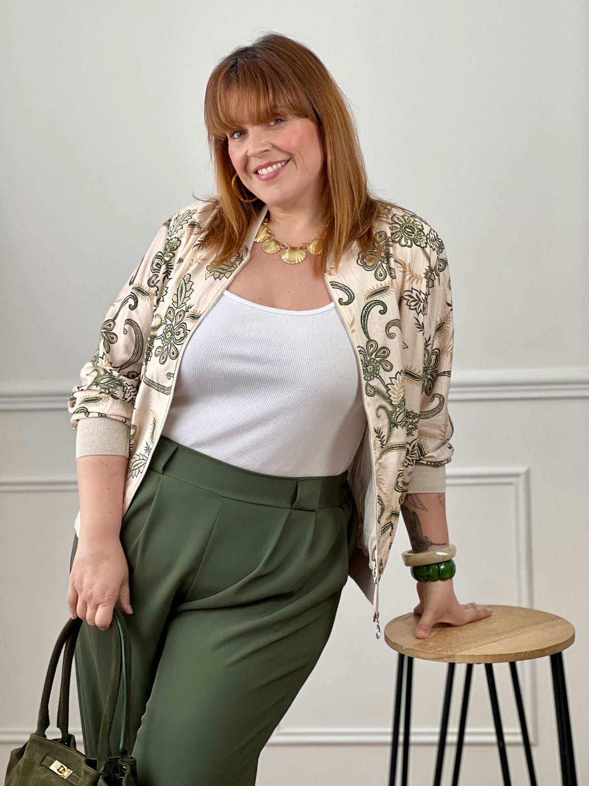 Laissez-vous séduire par ce bomber à motifs grande taille femme, une pièce tendance qui booste instantanément votre look. Sa coupe style bomber et sa fermeture zippée argentée apportent une touche moderne, tandis que ses poches à l’avant ajoutent du côté pratique. Ses élastiques beige et argentés au col, aux poignets et à la base structurent la silhouette, et ses motifs aux nuances vert clair, kaki, camel et doré apportent une touche chic et originale.