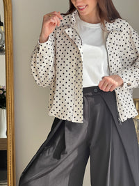 Veste femme écrue à pois noirs, légère et tendance, parfaite pour compléter un look chic et décontracté. Dotée de manches longues, d’une fermeture éclair et de poches latérales pratiques, elle allie style et fonctionnalité. Les boutons aux manches et l’élastique sur le bas apportent une finition moderne et confortable. Un indispensable facile à porter en toute saison.