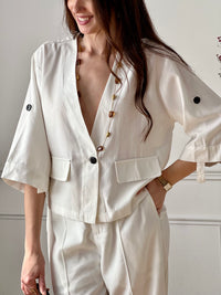 Cette veste légère écru est parfaite pour la mi-saison. Ses manches retroussables apportent une touche pratique et décontractée, tandis que ses poches factices ajoutent du style. Facile à porter, elle complète idéalement toutes vos tenues.