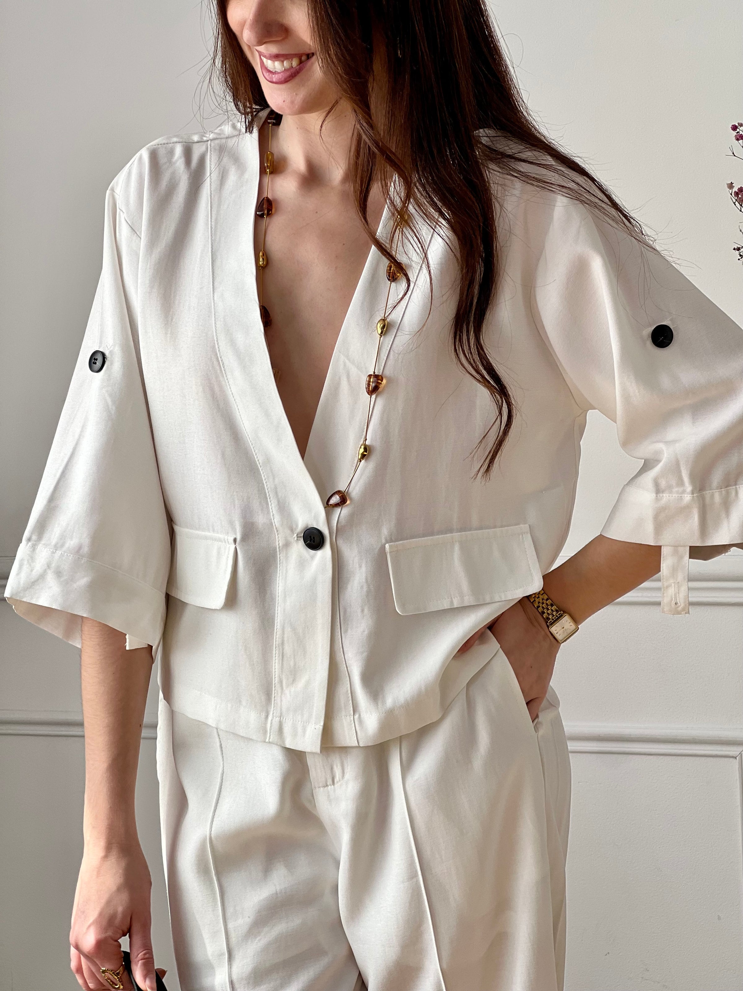 Cette veste légère écru est parfaite pour la mi-saison. Ses manches retroussables apportent une touche pratique et décontractée, tandis que ses poches factices ajoutent du style. Facile à porter, elle complète idéalement toutes vos tenues.