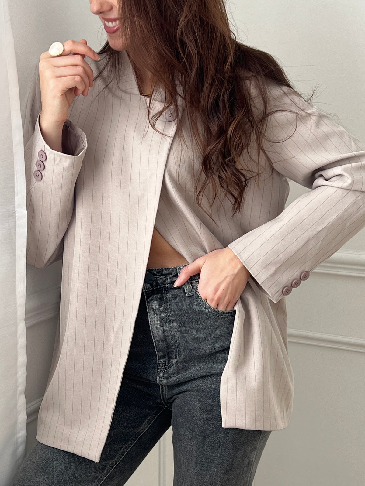 Optez pour cette veste taupe à rayures au style moderne et structuré. Sa coupe asymétrique croisée sur le devant lui apporte une allure élégante et originale. Dotée de manches longues, d’un col montant et d’un bouton sur le haut, elle est doublée pour plus de confort. Une veste noire chic, idéale pour compléter vos tenues.