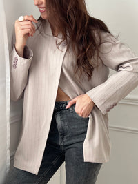 Optez pour cette veste taupe à rayures au style moderne et structuré. Sa coupe asymétrique croisée sur le devant lui apporte une allure élégante et originale. Dotée de manches longues, d’un col montant et d’un bouton sur le haut, elle est doublée pour plus de confort. Une veste noire chic, idéale pour compléter vos tenues.