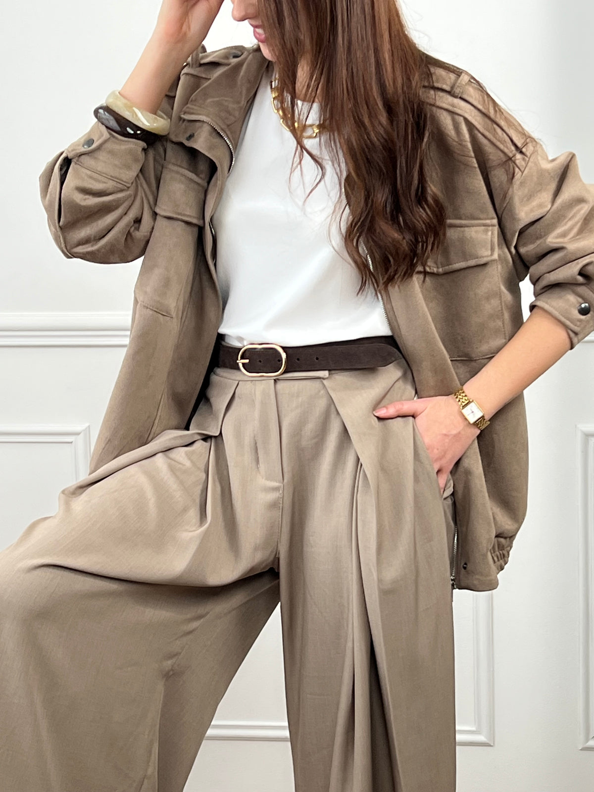 Veste en suédine taupe, élégante et facile à porter au quotidien. Dotée de manches longues, d’un col montant et d’une fermeture zippée avec boutons. Ses poches pratiques et sa coupe resserrée à la taille offrent confort et style. Une pièce tendance idéale pour compléter vos looks de saison.