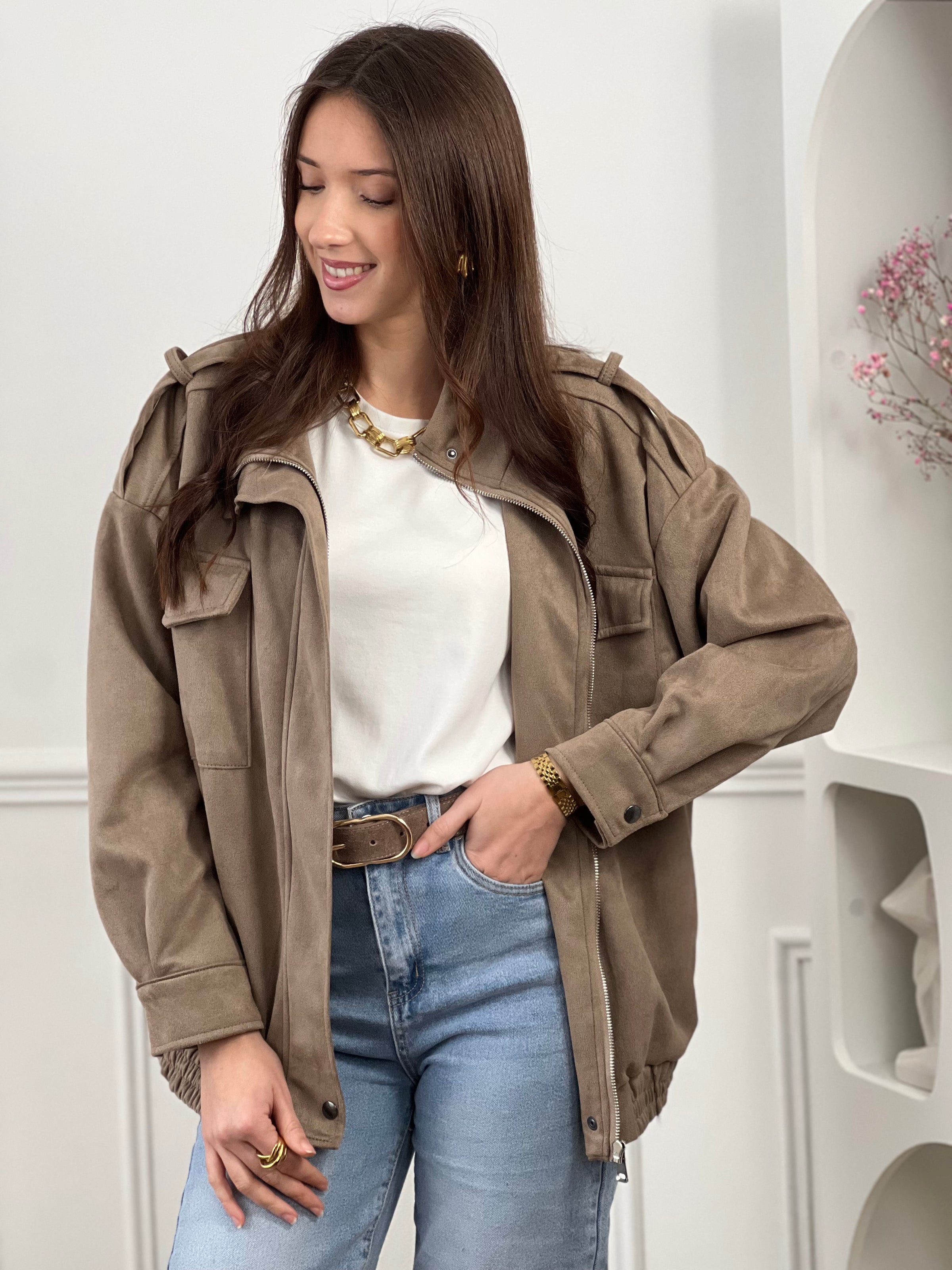 Veste en suédine taupe, élégante et facile à porter au quotidien. Dotée de manches longues, d’un col montant et d’une fermeture zippée avec boutons. Ses poches pratiques et sa coupe resserrée à la taille offrent confort et style. Une pièce tendance idéale pour compléter vos looks de saison.