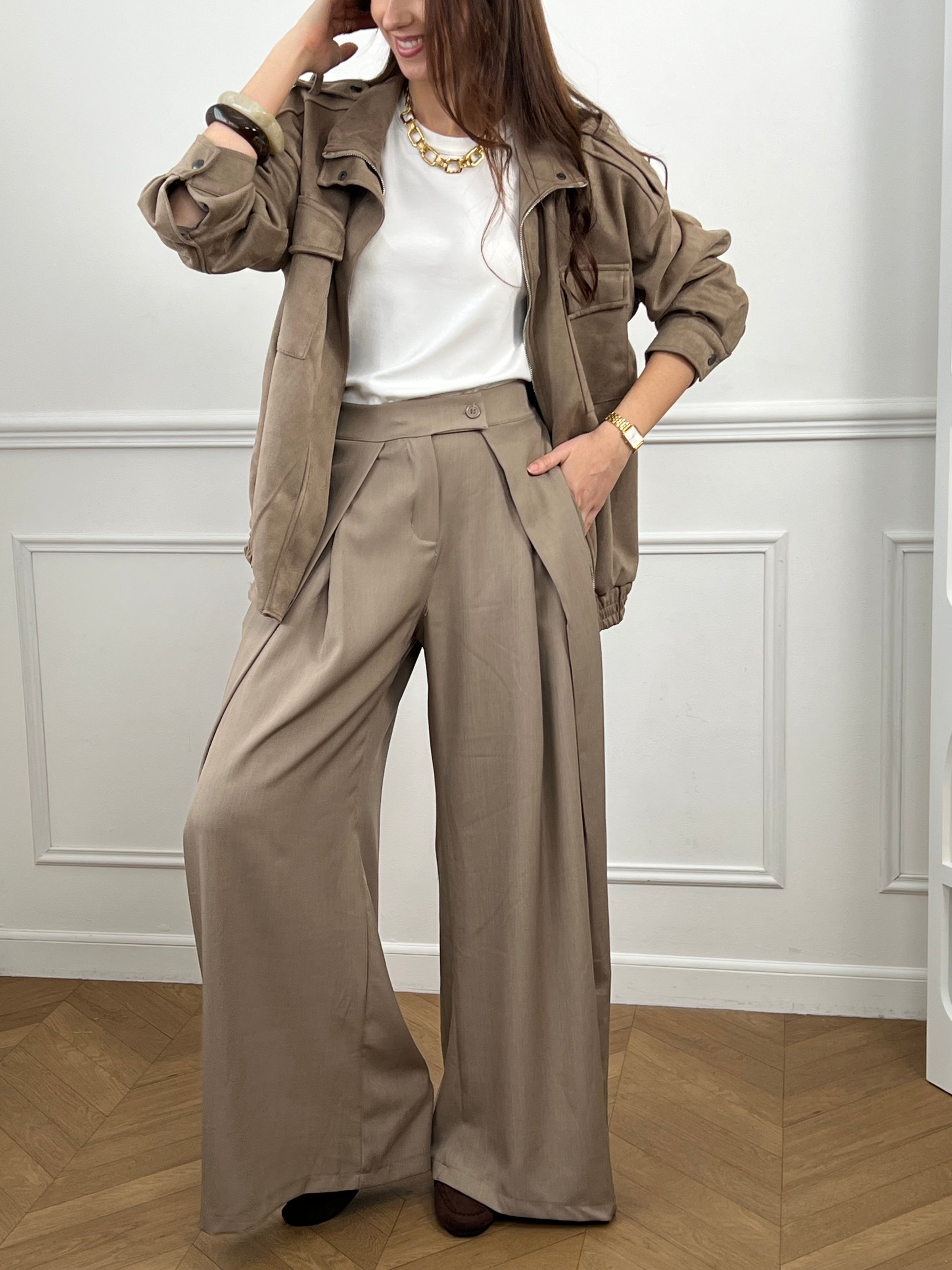 Veste en suédine taupe, élégante et facile à porter au quotidien. Dotée de manches longues, d’un col montant et d’une fermeture zippée avec boutons. Ses poches pratiques et sa coupe resserrée à la taille offrent confort et style. Une pièce tendance idéale pour compléter vos looks de saison.
