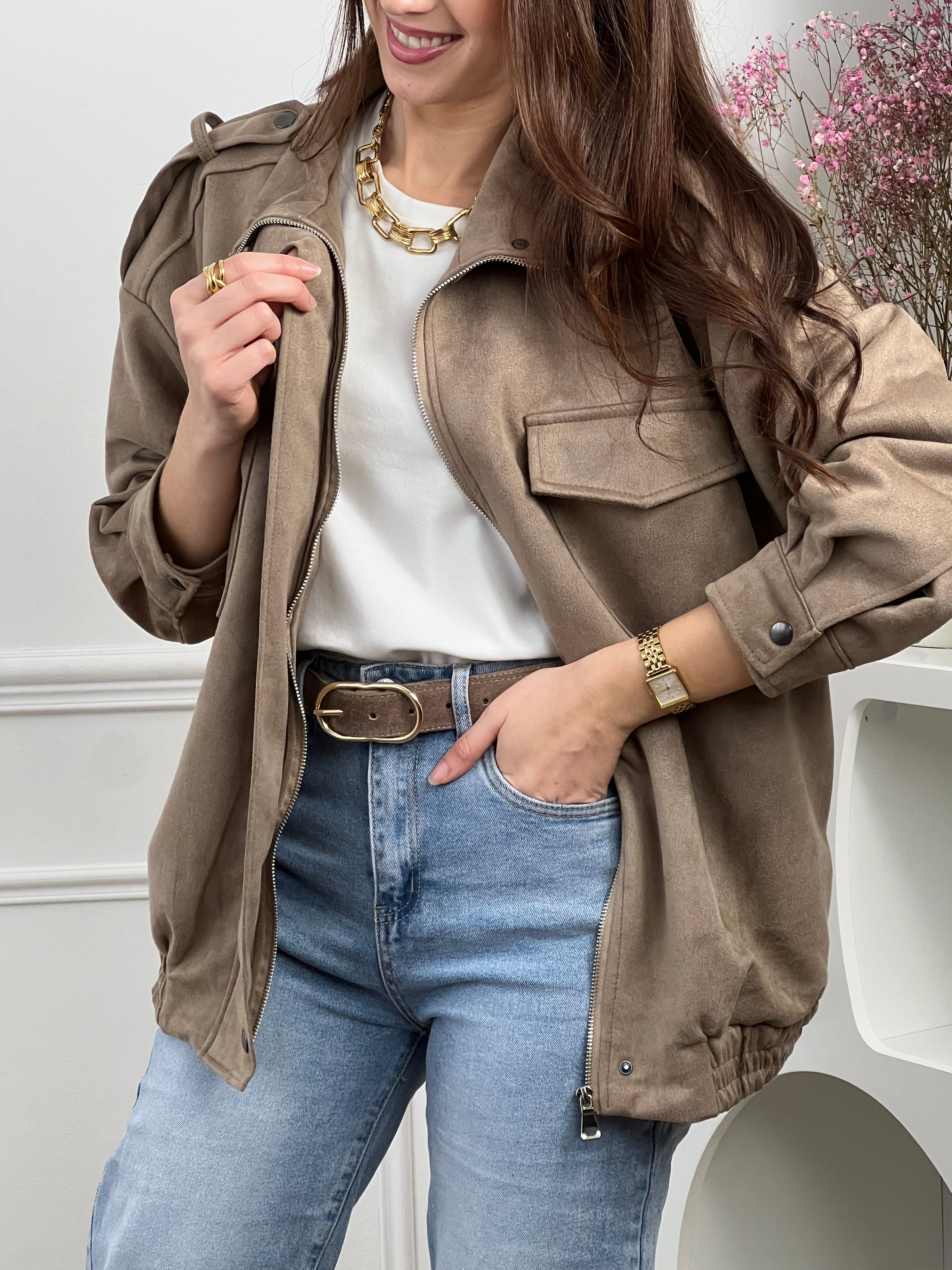 Veste en suédine taupe, élégante et facile à porter au quotidien. Dotée de manches longues, d’un col montant et d’une fermeture zippée avec boutons. Ses poches pratiques et sa coupe resserrée à la taille offrent confort et style. Une pièce tendance idéale pour compléter vos looks de saison.