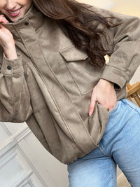 Veste en suédine taupe, élégante et facile à porter au quotidien. Dotée de manches longues, d’un col montant et d’une fermeture zippée avec boutons. Ses poches pratiques et sa coupe resserrée à la taille offrent confort et style. Une pièce tendance idéale pour compléter vos looks de saison.