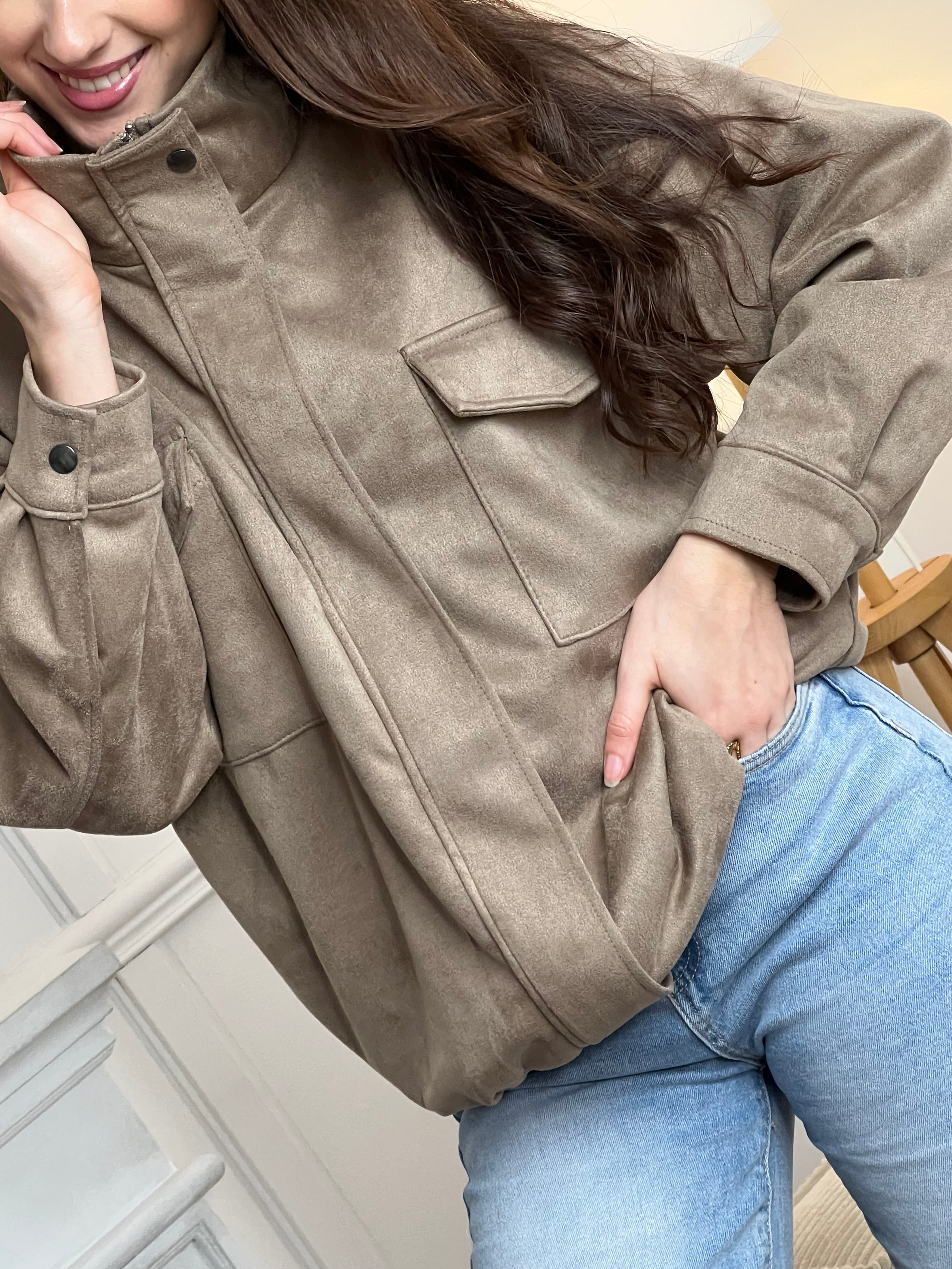 Veste en suédine taupe, élégante et facile à porter au quotidien. Dotée de manches longues, d’un col montant et d’une fermeture zippée avec boutons. Ses poches pratiques et sa coupe resserrée à la taille offrent confort et style. Une pièce tendance idéale pour compléter vos looks de saison.