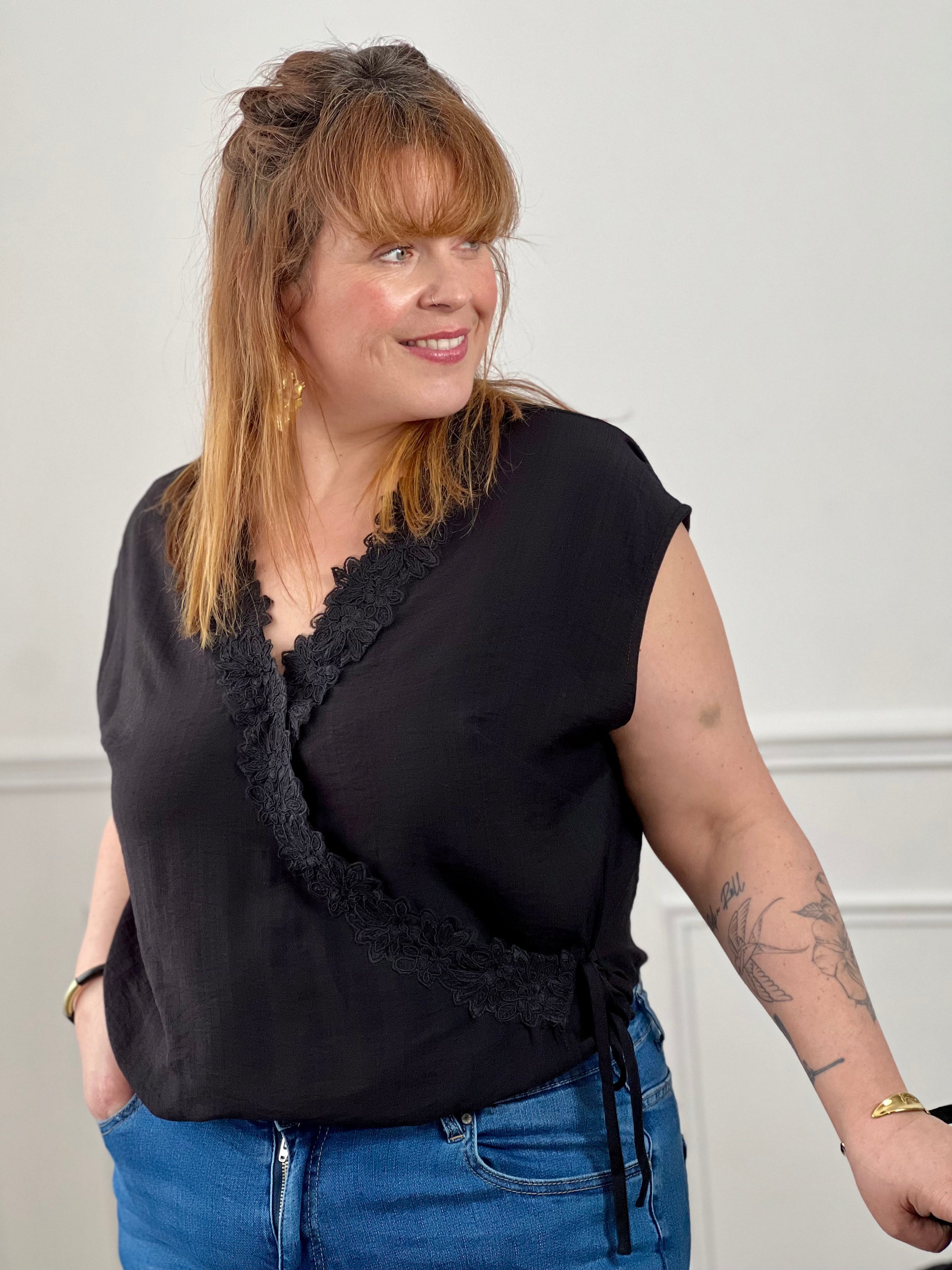 Craquez pour ce top croisé noir grande taille femme, lumineux et féminin. Sans manches, il se distingue par sa fermeture croisée avec lien à nouer effet portefeuille qui sublime la silhouette. Son col V avec clip et ses motifs fleurs brodés apportent une touche délicate et élégante à ce modèle corail plein de charme.