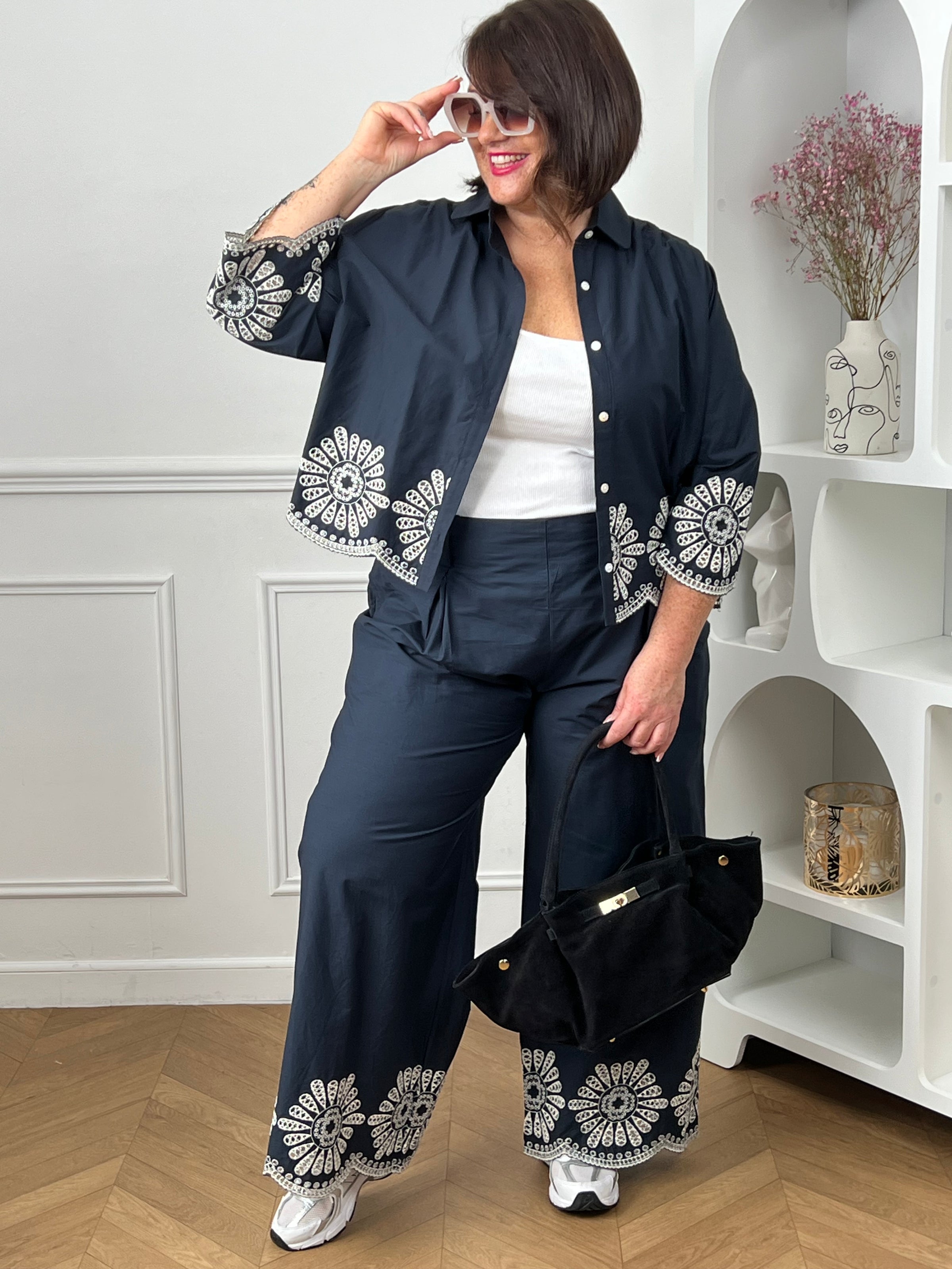 Chemise bleue en coton grande taille, idéale pour un look à la fois élégant et confortable. Dotée de boutons sur toute la longueur et aux manches, elle allie praticité et style. Ses détails de broderie blanche ajourée apportent une touche raffinée et féminine. Confectionnée en 100% coton, elle offre douceur et respirabilité pour un porté agréable au quotidien.