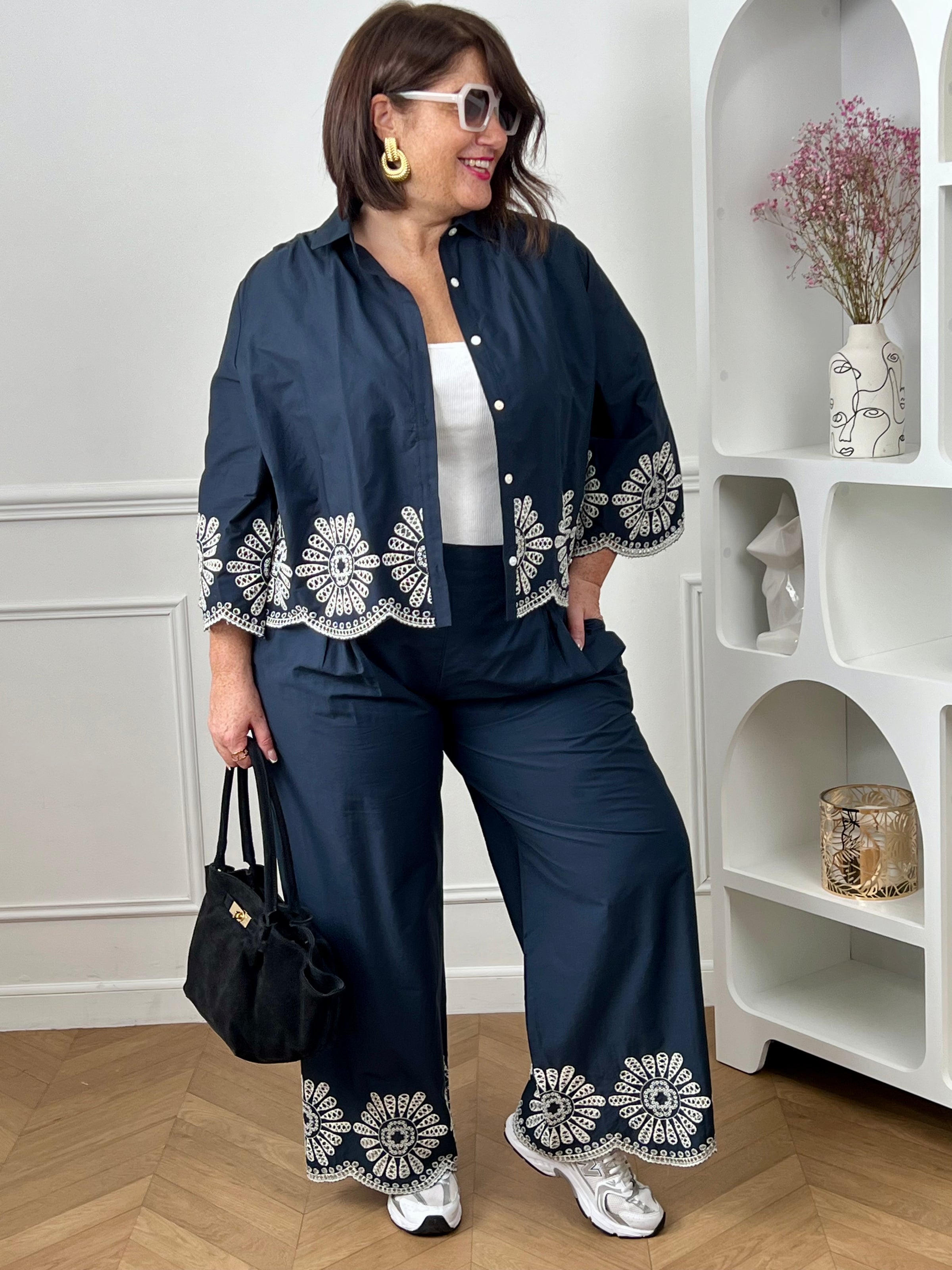 Chemise bleue en coton grande taille, idéale pour un look à la fois élégant et confortable. Dotée de boutons sur toute la longueur et aux manches, elle allie praticité et style. Ses détails de broderie blanche ajourée apportent une touche raffinée et féminine. Confectionnée en 100% coton, elle offre douceur et respirabilité pour un porté agréable au quotidien.