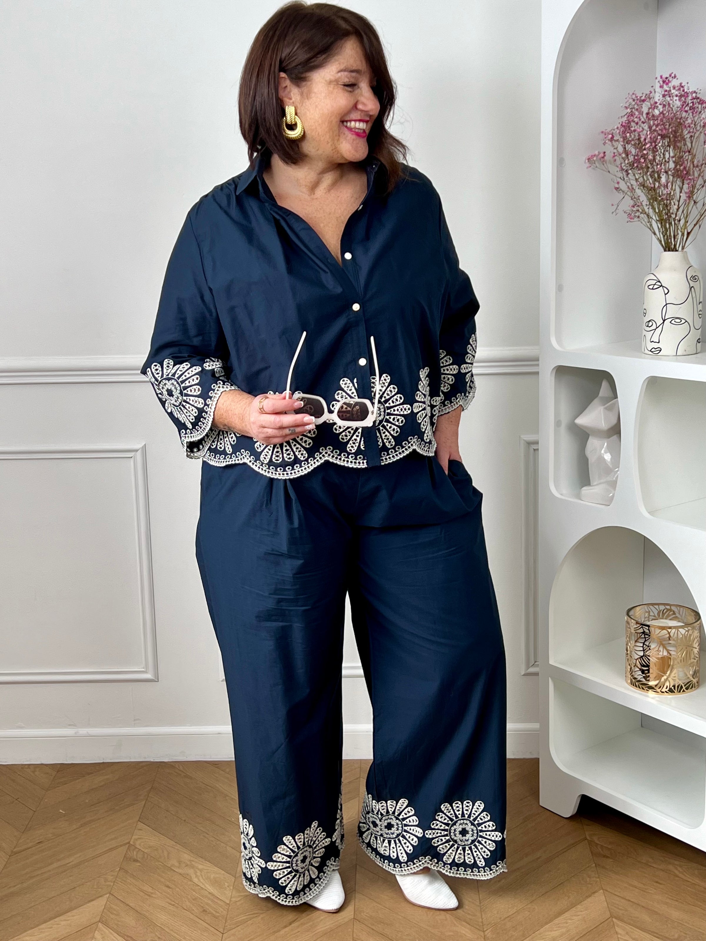 Chemise bleue en coton grande taille, idéale pour un look à la fois élégant et confortable. Dotée de boutons sur toute la longueur et aux manches, elle allie praticité et style. Ses détails de broderie blanche ajourée apportent une touche raffinée et féminine. Confectionnée en 100% coton, elle offre douceur et respirabilité pour un porté agréable au quotidien.