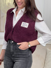 Sobre et tendance, ce gilet sans manches bordeaux se distingue par sa petite inscription discrète sur le côté. Une pièce moderne et stylée, parfaite pour apporter une touche de caractère tout en restant raffinée.