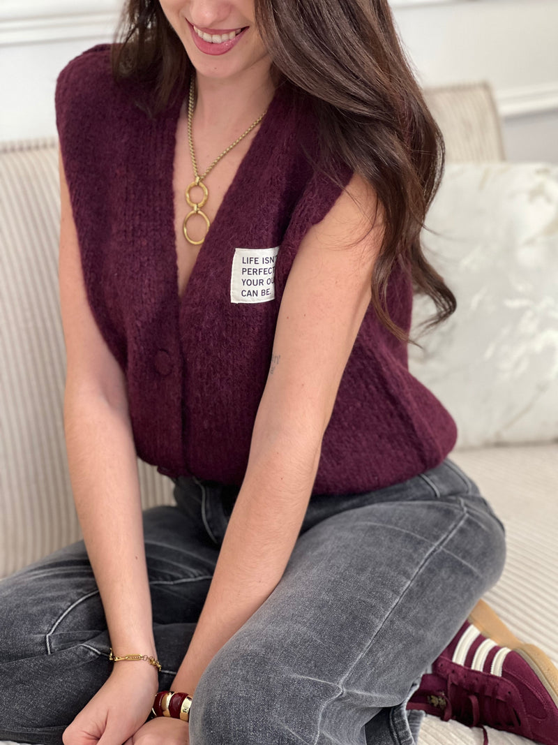 Sobre et tendance, ce gilet sans manches bordeaux se distingue par sa petite inscription discrète sur le côté. Une pièce moderne et stylée, parfaite pour apporter une touche de caractère tout en restant raffinée.