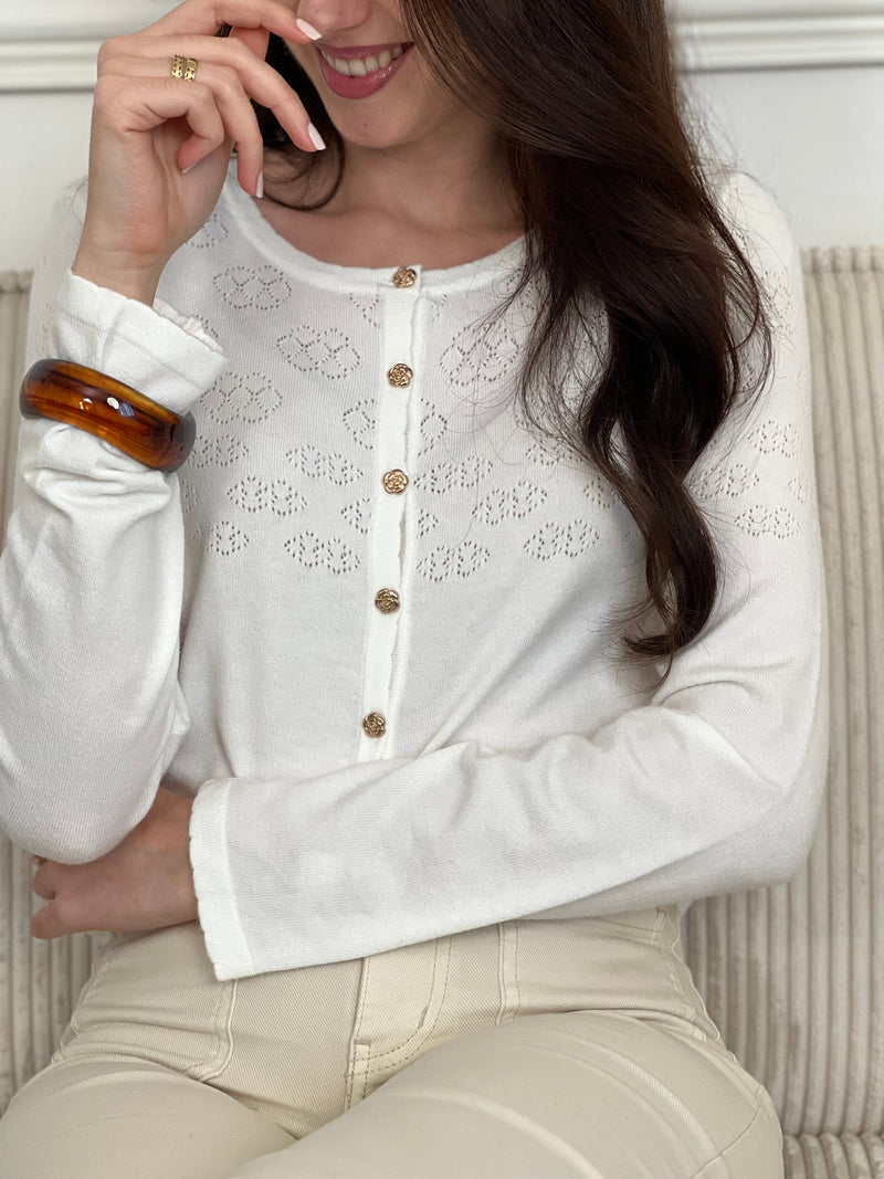 Découvrez le Gilet Davina, une pièce incontournable pour sublimer vos tenues. Confectionné dans une matière fine et délicate, ce gilet écru épouse élégamment votre silhouette. Ses manches longues et ses boutons dorés alignés sur toute la longueur ajoutent une touche de raffinement.