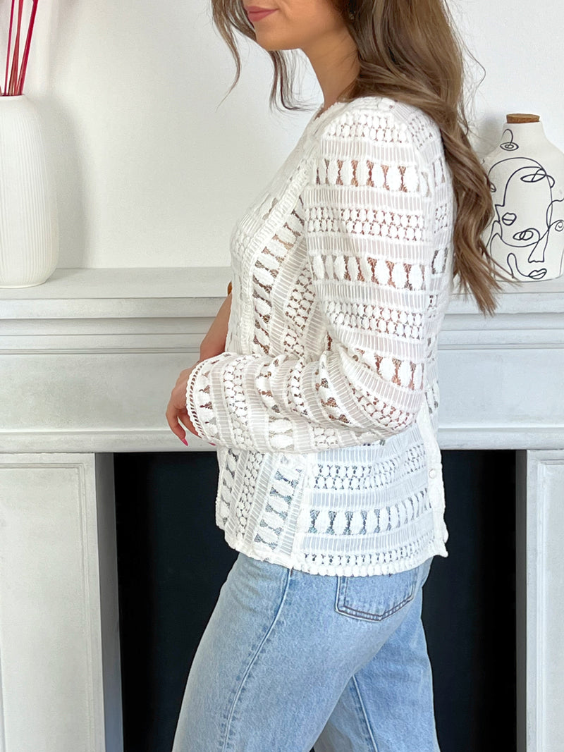 Blouse blanche broderie Blouse manches longues ajourée Blouse en broderie Doublée sur le devant et transparente au dos et sur les manches Couleur : écru Boutons au dos Composition: 60% Coton, 40% Nylon Made in P.R.C