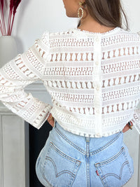 Blouse blanche broderie Blouse manches longues ajourée Blouse en broderie Doublée sur le devant et transparente au dos et sur les manches Couleur : écru Boutons au dos Composition: 60% Coton, 40% Nylon Made in P.R.C