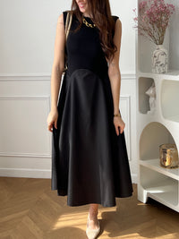 Cette robe longue noire sans manches séduit par son élégance et son jeu de matières. Son design bi-matière apporte du relief et une touche moderne, tout en restant facile à porter. Une pièce chic et intemporelle, idéale pour toutes les occasions.