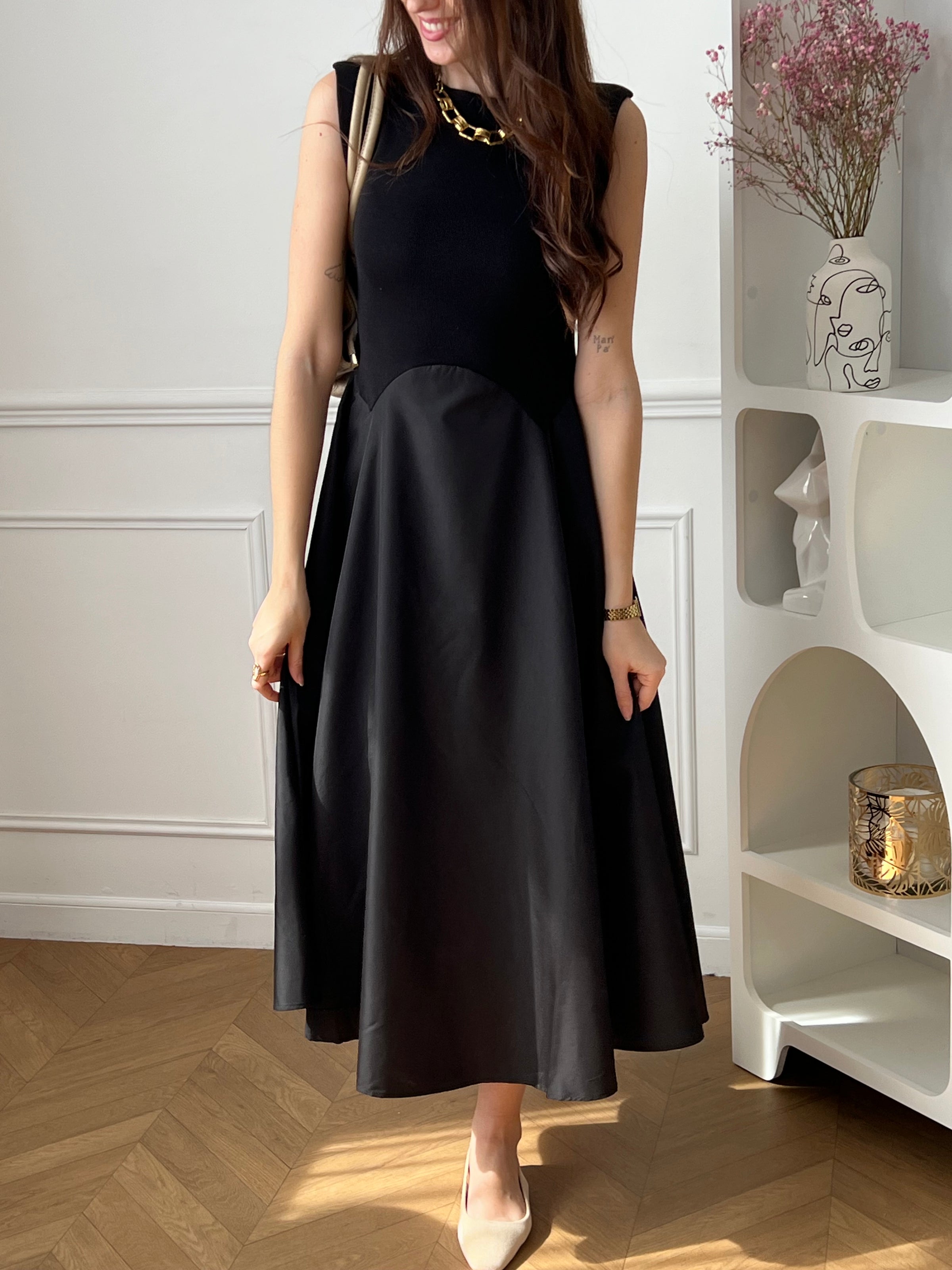 Cette robe longue noire sans manches séduit par son élégance et son jeu de matières. Son design bi-matière apporte du relief et une touche moderne, tout en restant facile à porter. Une pièce chic et intemporelle, idéale pour toutes les occasions.