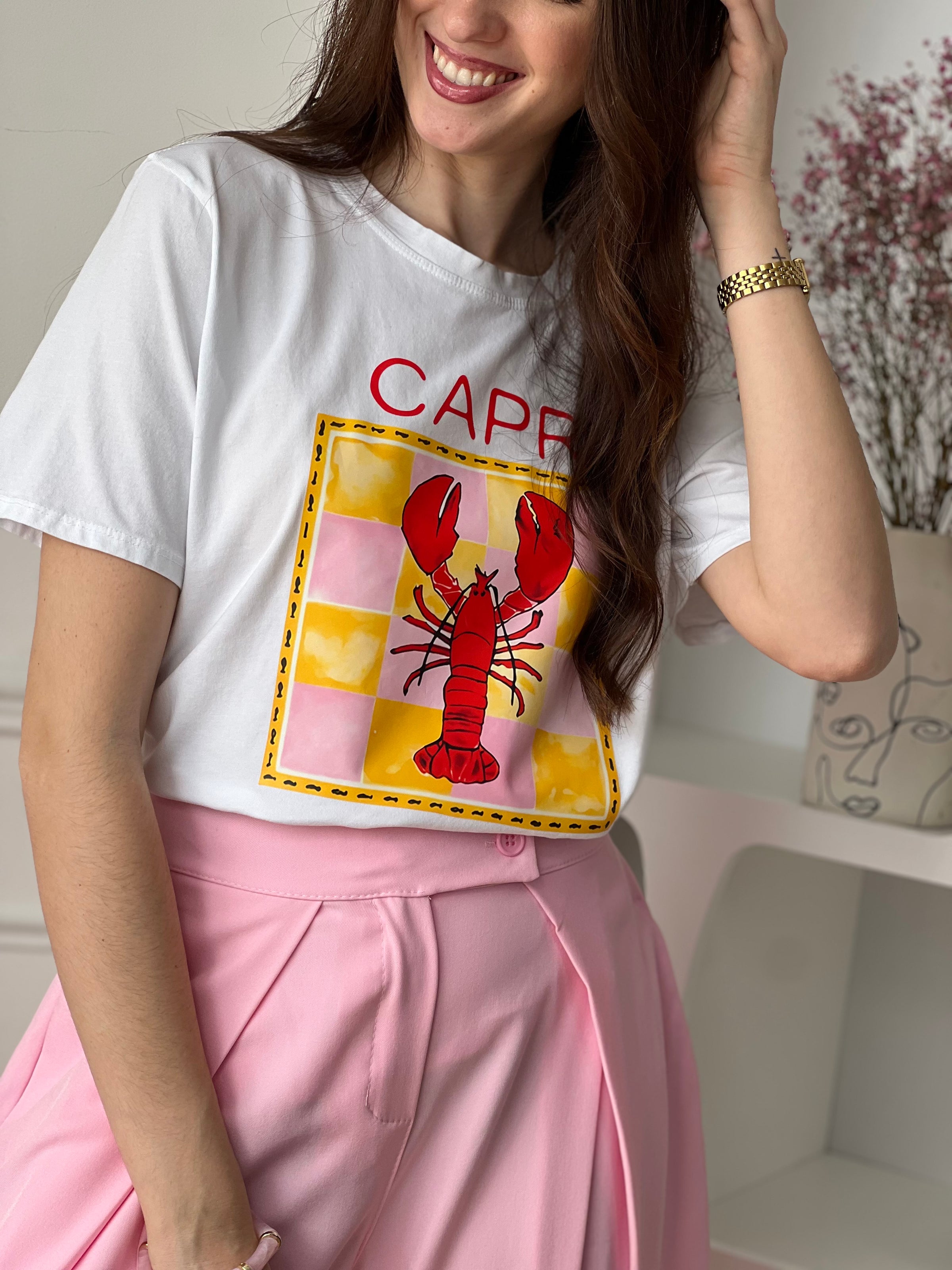 Craquez pour ce top écru femme, original et plein de caractère. Doté de manches courtes et d’un col rond, il se distingue par son illustration de homard accompagnée de motifs jaunes et roses et de l’inscription “Capri Aragosta” en rouge. Une pièce idéale pour un look estival et tendance.