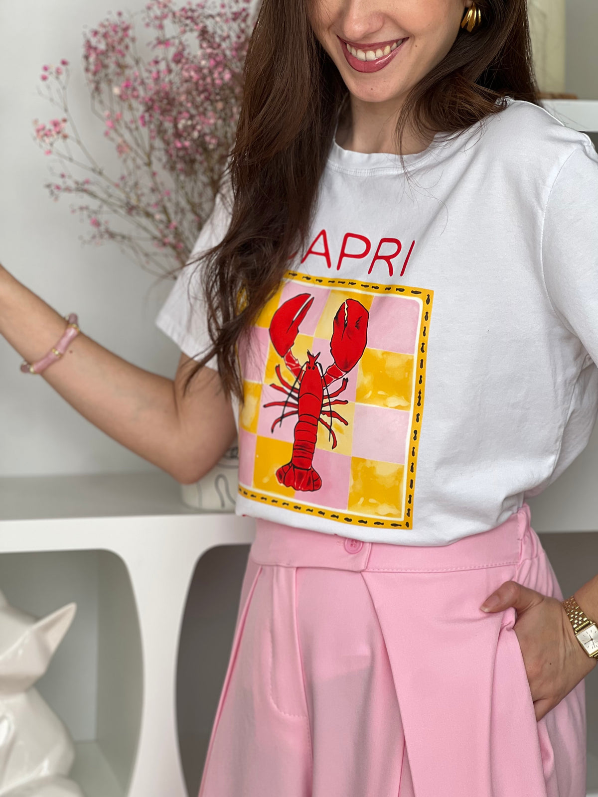 Craquez pour ce top écru femme, original et plein de caractère. Doté de manches courtes et d’un col rond, il se distingue par son illustration de homard accompagnée de motifs jaunes et roses et de l’inscription “Capri Aragosta” en rouge. Une pièce idéale pour un look estival et tendance.