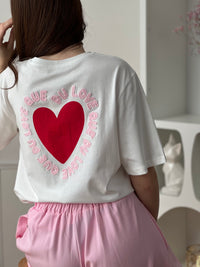 Ce tee-shirt écru en 100 % coton allie confort et style au quotidien. Son inscription « que du love » en rose, entourant un cœur rouge, apporte une touche douce et tendance. Facile à associer, il est parfait pour un look casual plein de good vibes.